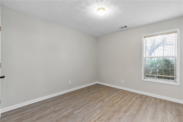 empty room featuring light hardwood / wood-style floors and a textured ceiling