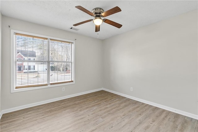 empty room featuring light hardwood / wood-style floors, ceiling fan, and a textured ceiling