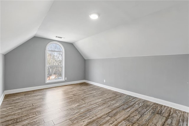 bonus room with vaulted ceiling and hardwood / wood-style floors