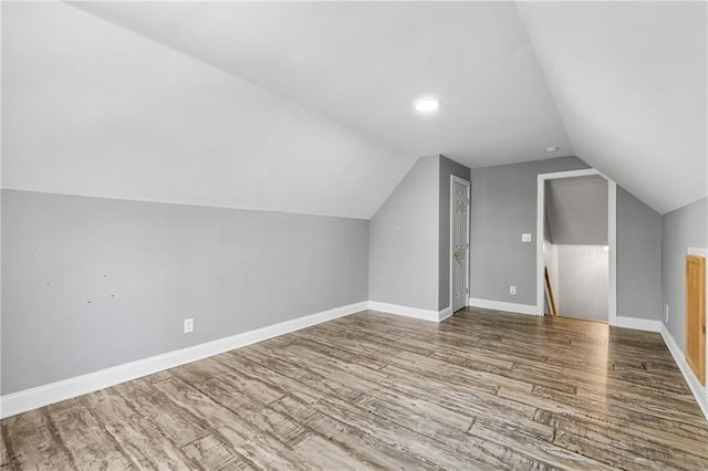 additional living space featuring hardwood / wood-style flooring and vaulted ceiling