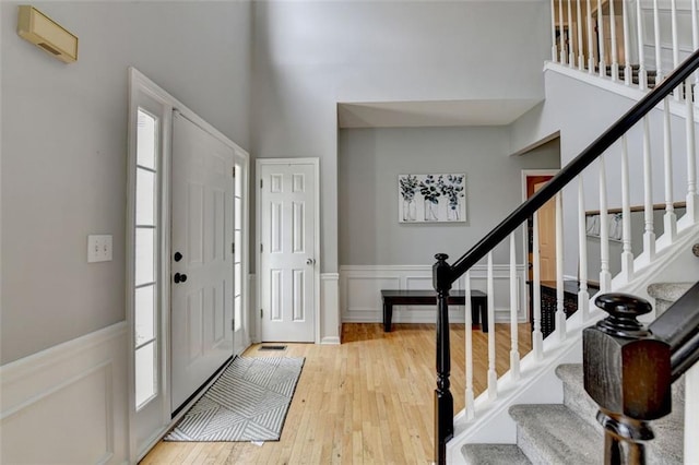 3845 Lake Lanier Dr, Duluth, GA 30097 - foyer with hardwood / wood-style floors, a high ceiling, stairs, a wainscoted wall, and a decorative wall