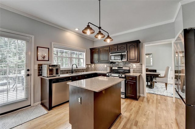 3845 Lake Lanier Dr, Duluth, GA 30097 - kitchen with stainless steel appliances, ornamental molding, dark brown cabinets, tasteful backsplash, and a center island