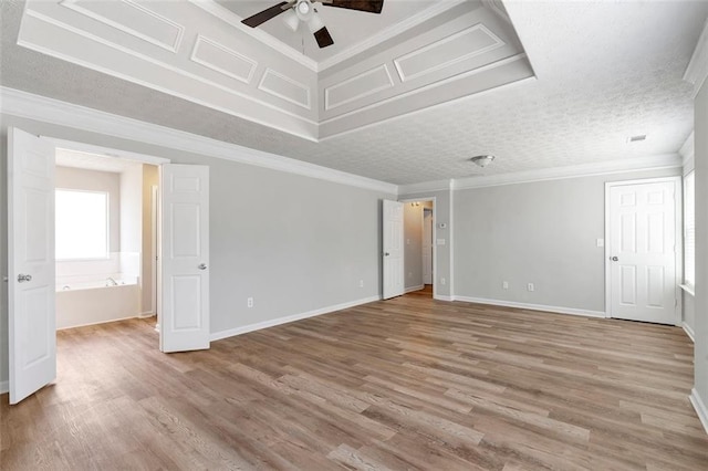 empty room featuring ceiling fan, ornamental molding, hardwood / wood-style floors, and a textured ceiling