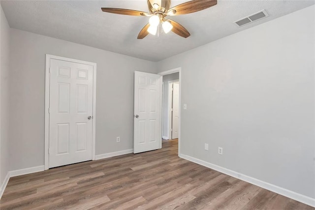 unfurnished bedroom with wood-type flooring and ceiling fan