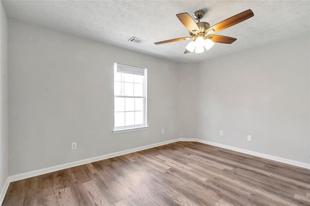 spare room featuring hardwood / wood-style flooring, ceiling fan, and a textured ceiling