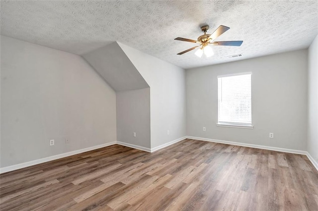 bonus room featuring hardwood / wood-style floors, a textured ceiling, and ceiling fan