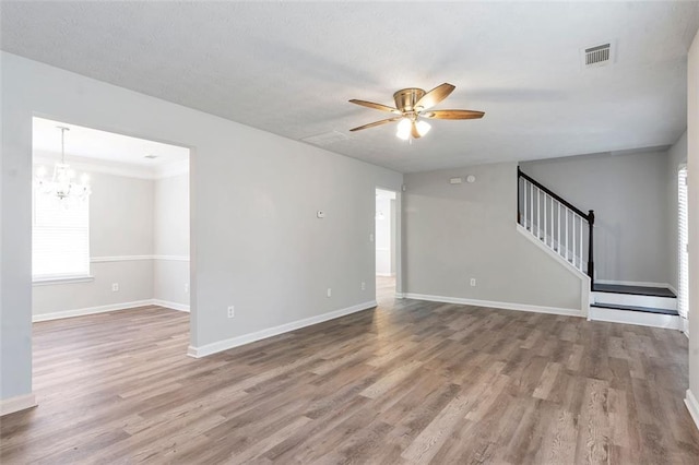 unfurnished living room with hardwood / wood-style flooring and ceiling fan with notable chandelier