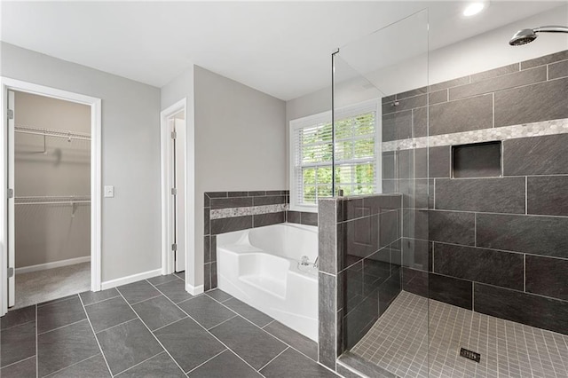 2994 Meadow Church Rd, Suwanee, GA 30024 - bathroom with a garden tub, a stall shower, a spacious closet, tile patterned flooring, and baseboards