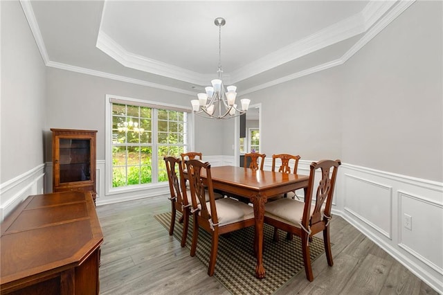 2994 Meadow Church Rd, Suwanee, GA 30024 - dining room with a chandelier, a raised ceiling, light wood-style floors, crown molding, and wainscoting