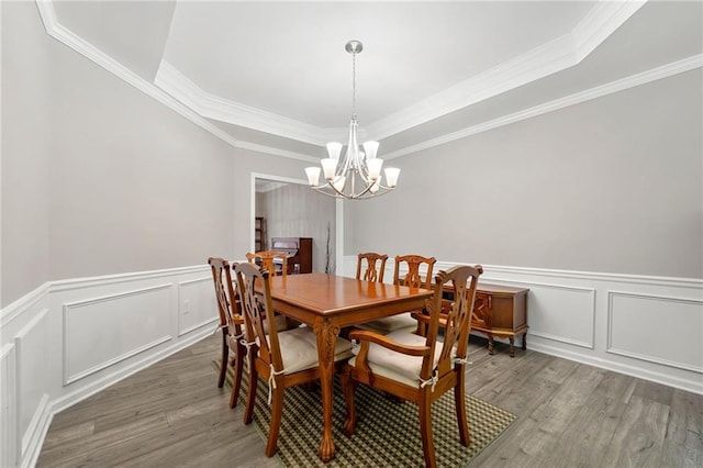 2994 Meadow Church Rd, Suwanee, GA 30024 - dining room featuring wood finished floors, a tray ceiling, a chandelier, a decorative wall, and crown molding