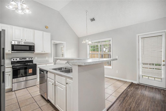 104 Terrapin Ct, Carrollton, GA 30116 - kitchen featuring stainless steel appliances, a chandelier, lofted ceiling, light countertops, and white cabinetry