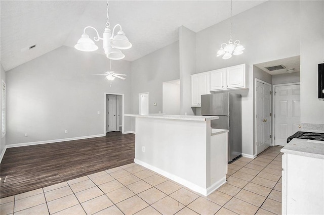 104 Terrapin Ct, Carrollton, GA 30116 - kitchen featuring a chandelier, high vaulted ceiling, freestanding refrigerator, light tile patterned flooring, and white cabinets