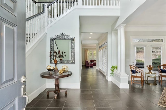 foyer entrance with baseboards, stairway, ornamental molding, ornate columns, and dark tile patterned floors