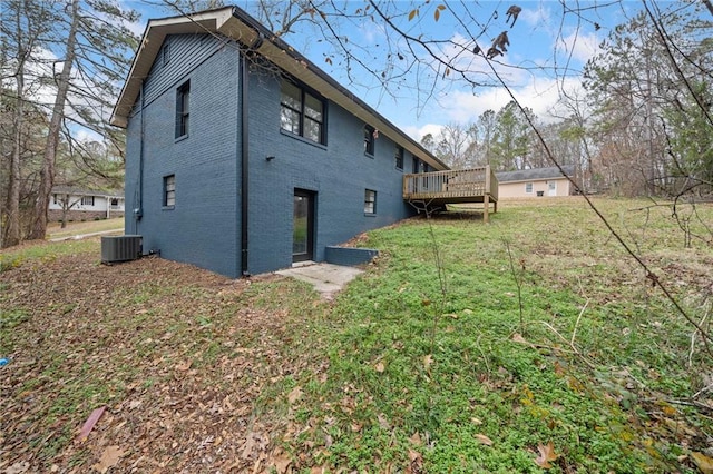 rear view of property with central air condition unit, a yard, and a deck