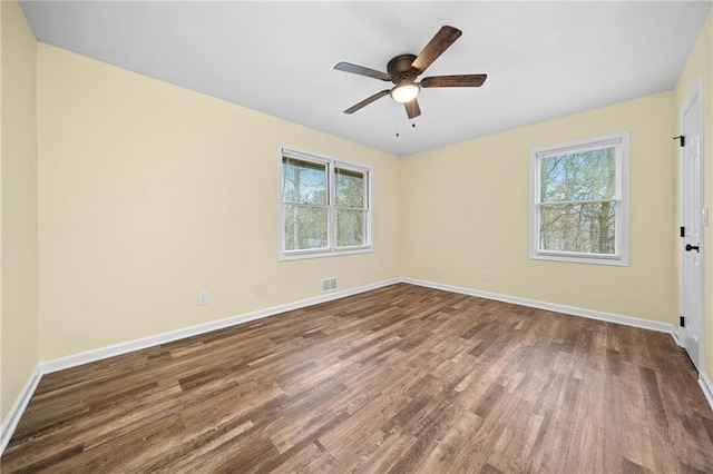 unfurnished room with a wealth of natural light, hardwood / wood-style floors, and ceiling fan