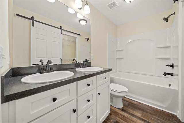 full bathroom with vanity, hardwood / wood-style flooring, toilet, and  shower combination