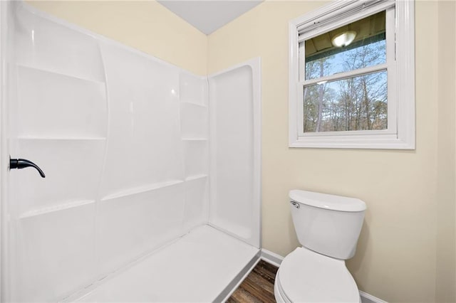 bathroom featuring hardwood / wood-style flooring, toilet, and walk in shower