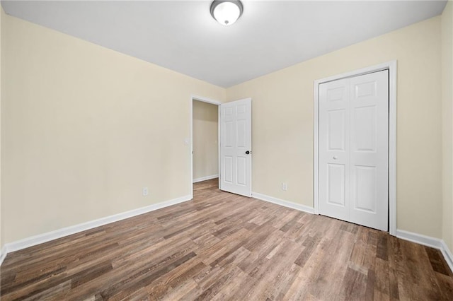 unfurnished bedroom with hardwood / wood-style floors and a closet