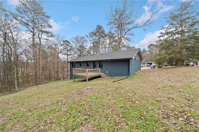 rear view of property with a yard and a deck