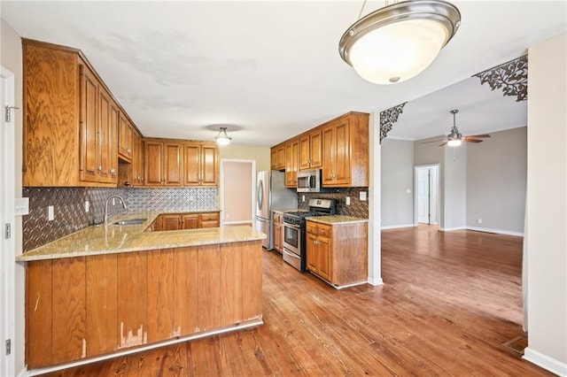 105 Spring Forest Way, Sharpsburg, GA 30277 - kitchen with a peninsula, brown cabinets, stainless steel appliances, and a sink