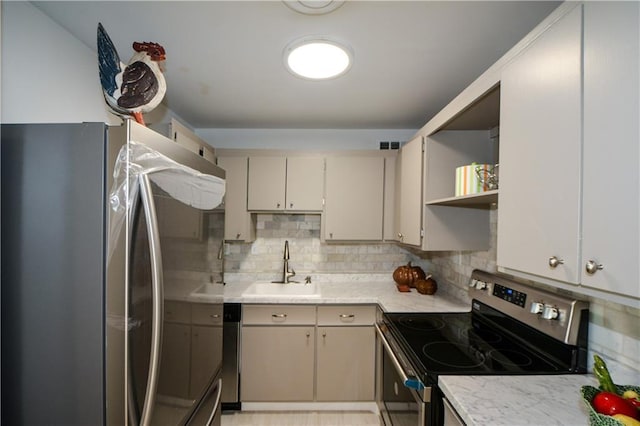 kitchen with sink, decorative backsplash, stainless steel appliances, and cream cabinetry