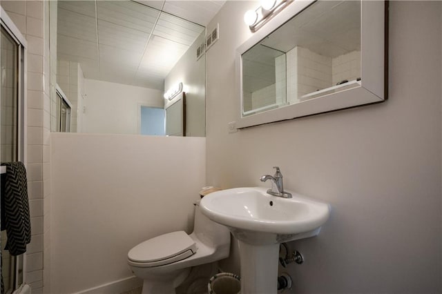 bathroom featuring toilet and walk in shower