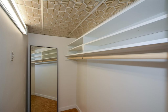 walk in closet featuring parquet floors