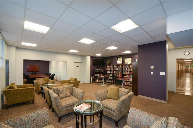 living room with a paneled ceiling and carpet flooring