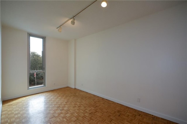 unfurnished room featuring track lighting and light parquet floors