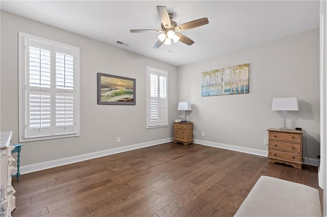 bedroom with ceiling fan, visible vents, baseboards, and wood finished floors