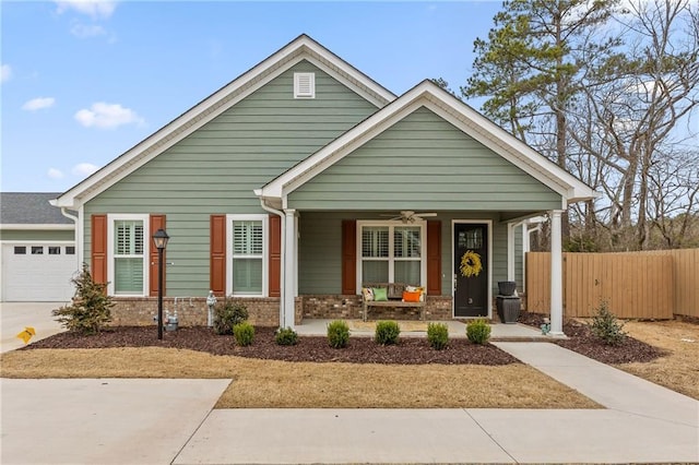 view of front of property featuring a porch, fence, an attached garage, brick siding, and ceiling fan