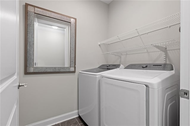 laundry room featuring tile patterned flooring, laundry area, baseboards, and washer and clothes dryer