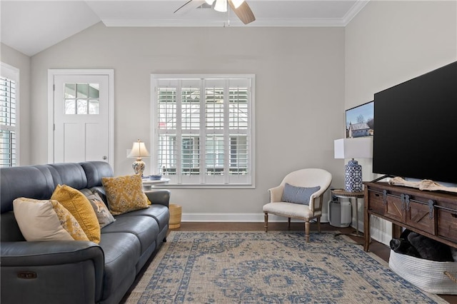 living room featuring wood finished floors, a ceiling fan, baseboards, vaulted ceiling, and crown molding