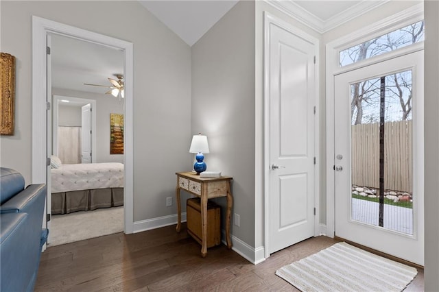 entryway with ornamental molding, wood finished floors, baseboards, ceiling fan, and vaulted ceiling