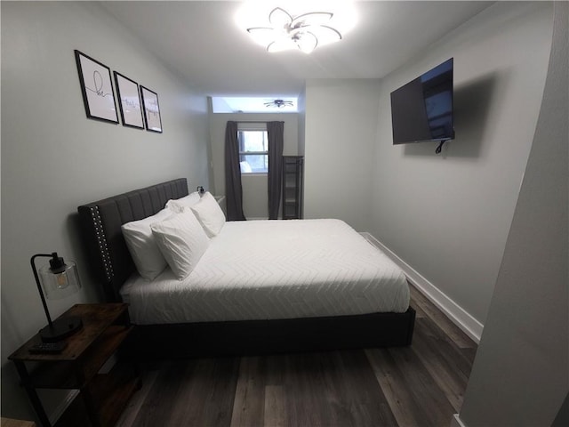 bedroom with baseboards and dark wood-style flooring