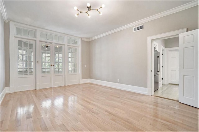 unfurnished room with light wood finished floors, french doors, ornamental molding, and a chandelier