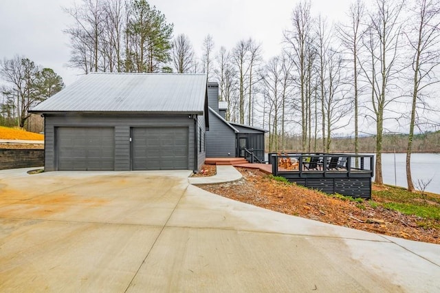 view of side of property featuring a deck with water view and a garage