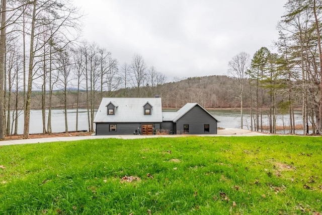 view of front facade featuring a water and mountain view and a front yard