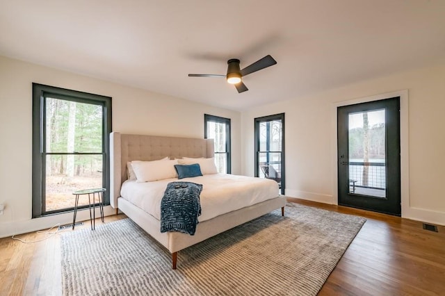 bedroom with hardwood / wood-style flooring, access to outside, and ceiling fan