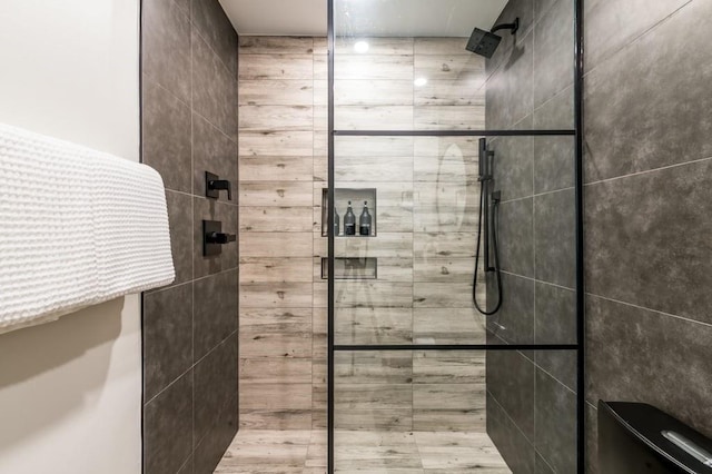 bathroom featuring tiled shower and toilet