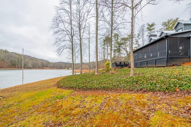 view of yard with a water view and a sunroom