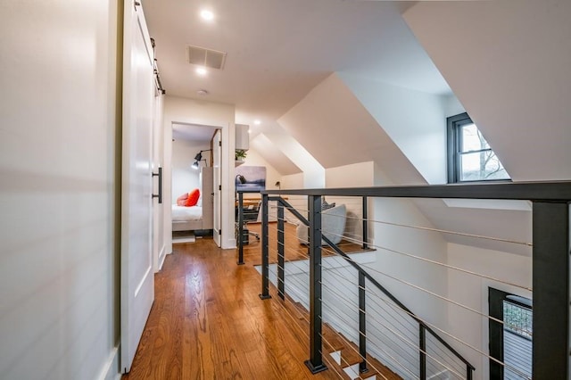 hallway with hardwood / wood-style flooring and vaulted ceiling