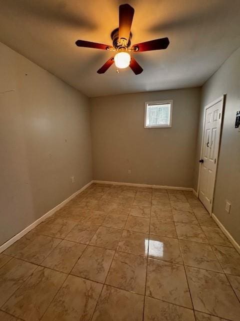 spare room with light tile patterned floors, a ceiling fan, and baseboards