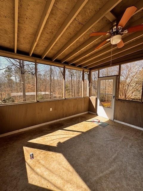 unfurnished sunroom featuring a ceiling fan