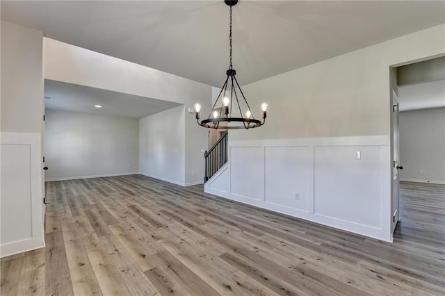 unfurnished dining area featuring a chandelier and light hardwood / wood-style floors