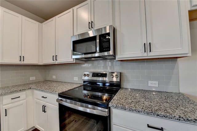 kitchen featuring stainless steel appliances, white cabinetry, and decorative backsplash