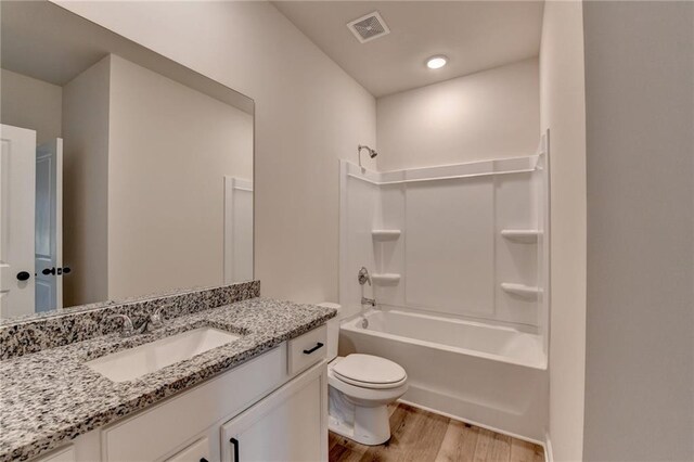 full bathroom featuring hardwood / wood-style floors, vanity, toilet, and shower / bath combination