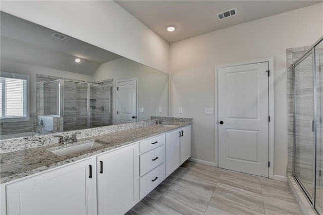 bathroom featuring an enclosed shower and vanity