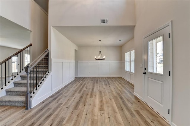 entrance foyer with light hardwood / wood-style floors and a notable chandelier