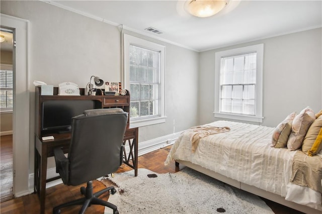 bedroom with ornamental molding and dark wood-type flooring